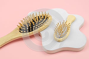 Wooden hairbrushes on a white plaster podium. Hairbrush made of natural material. Zero waste, no plastic