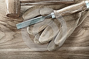 Wooden hammer chisel safety gloves on wood board