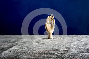 Wooden hand gesticulating against a blue background