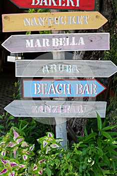 Wooden hand-painted signs of direction to many places in a resort.