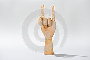 Wooden hand with rock sign on grey background