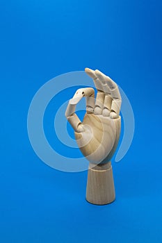 Wooden hand shows the ok sign on blue background. Positive concept