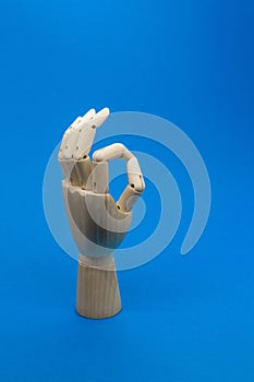 Wooden hand shows the ok sign on blue background. Positive concept.