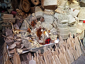 Wooden handmade bowls, spoons, boards, kitchen utensils and baskets on display at street market