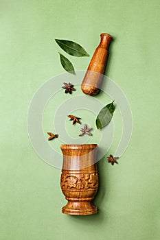 Wooden handmade mortar with pestle. Flat lay of Bay leaves and star anise. Ingredients for the dish. Top view