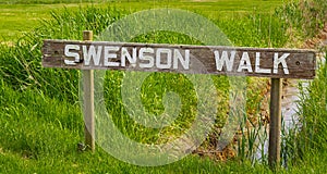 Wooden handmade sign in summer forest, park in Canada. Swenson Walk Park in British Columbia