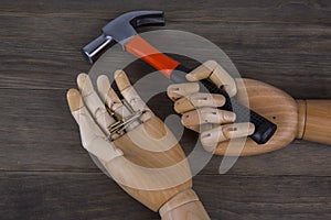 Wooden hands holding hammers and nails