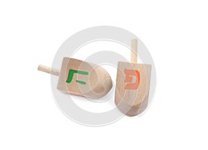 Wooden Hanukkah traditional dreidels with letters Pe and He on white background, top view