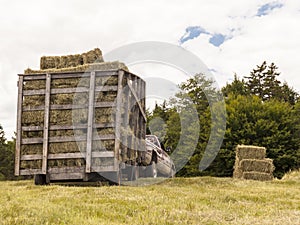 Wooden Hay Wagon Pulled by Truck in a Field