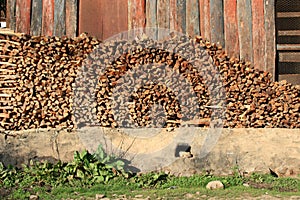 A wooden heap is stored in front of a warehouse in a village (Bhutan)