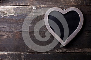 Wooden heart with blackboard on old brown wood