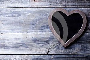 Wooden heart with blackboard on old gray wood