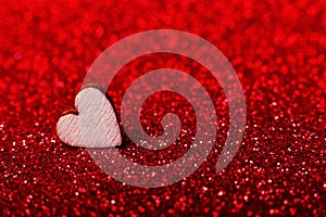 Wooden heart on brilliant red bright background for a festive decoration. Copy space