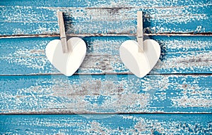 Wooden heart hanging on vintage blue wood background