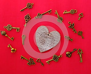 Wooden heart and many kyes on red background, love concept