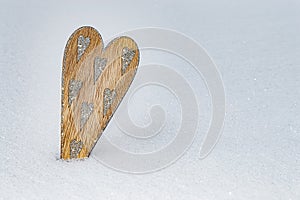 Wooden heart with many sharpen silver glittering hearts in snow