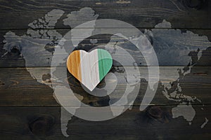 wooden heart with national flag of cote divoire near world map on the wooden background