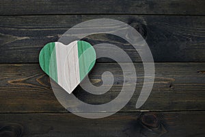 wooden heart with national flag of nigeria on the wooden background