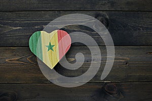 wooden heart with national flag of senegal on the wooden background