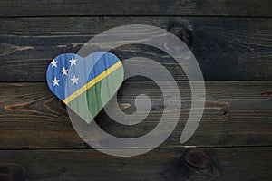 wooden heart with national flag of Solomon Islands on the wooden background