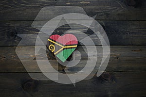 wooden heart with national flag of Vanuatu near reduce, reuse and recycle sing on the wooden background. concept