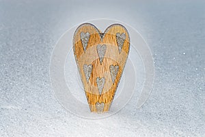 Wooden heart with sharpen silver glittering hearts in snow