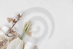 Wooden hearts, cotton flower and eco natural paper cups, string bag, wheat on white background