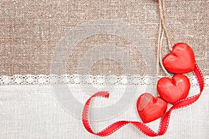 Wooden hearts, ribbon and linen cloth on the burlap
