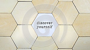 Wooden hexagon missing from puzzle, revealing the word Reinvent Yourself