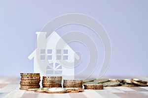 Wooden home and stack money coins of property investment concept