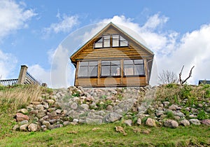 Wooden homestead house hill stone blue cloudy sky