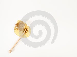 Wooden honey dipper, honeycomb, honey drop on white table with copy space, top view, flat lay