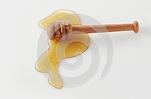 Wooden honey dipper and spilled honey