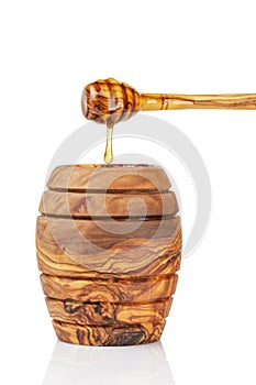 Wooden honey pot with dipper, isolated on white