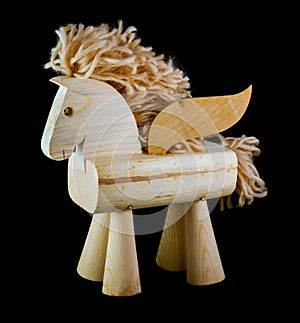 Wooden horse toy with wings on black background