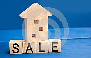 Wooden house on a blue background with the inscription sale. sale of property, home, real estate. affordable housing. place for te