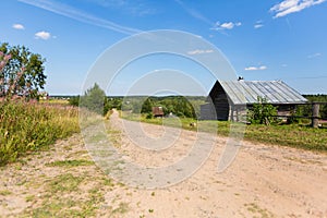 Wooden house and country road, rural landscape. Remote village in Karelia Republic