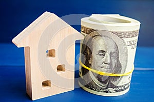 Wooden house and dollars on a blue background. concept of real estate. buying, selling, renting. credit for property. sale apartme