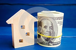 Wooden house and dollars on a blue background. concept of real estate. buying, selling, renting. credit for property. sale apartme