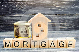 Wooden house and dollars. Wooden blocks and the inscription `mortgage`. credit for property. apartment. Business loans for real es