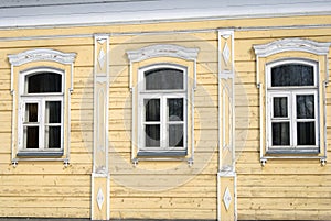 Wooden house facade with three windows