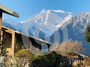 The wooden house at the foot of the snowy mountain