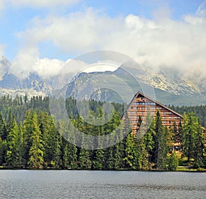 Wooden house in forest under mountains