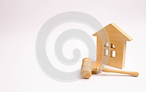 Wooden house and hammer of the judge on a white background. Concept trial property. The court decision on the transfer of property