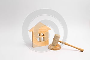 Wooden house and hammer of the judge on a white background. Concept trial property. The court decision on the transfer of property