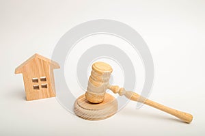 Wooden house and hammer of the judge on a white background. Concept trial property. The court decision on the transfer of property