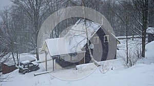 Wooden house during hard snowfall