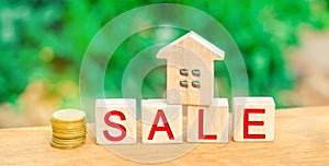 Wooden house with the inscription `sale`. sale of property, home, real estate. affordable housing.