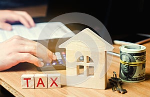 Wooden house with the inscription `Tax`. Taxes on real estate, payment. Penalty, arrears. Register of taxpayers for property. Law-