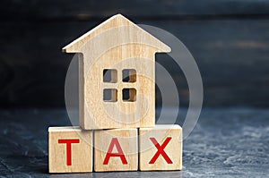 Wooden house with the inscription `Tax`. Taxes on real estate, payment. Penalty, arrears. Register of taxpayers for property. Law-